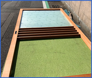 すりガラスが入っていないドアを外して地面に倒した画像