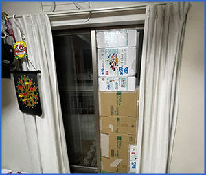 割れたガラスを段ボールで塞いでいる画像