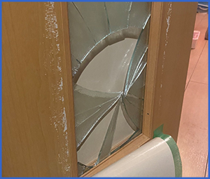 木製ドアのガラスがクモの巣状に割れた画像