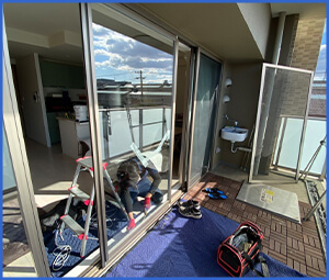 作業員が窓の張替えをしている画像