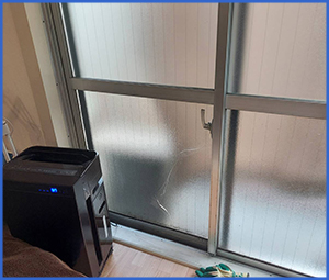 スライド式のすりガラス扉の下に亀裂が入っている画像