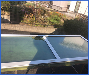 白枠すりガラスの窓に穴が開いている画像