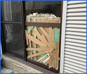 外から写したガラスにガムテープが大量に貼られている画像