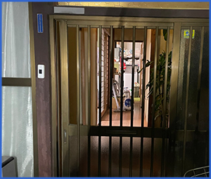 古めの玄関扉の割れたガラス画像