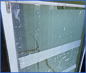 網入りの白テープで補強してあるガラス窓画像