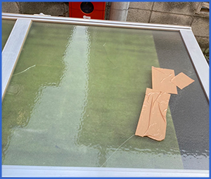 ガムテープがついている割れたガラス窓画像