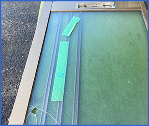 養生テープが貼ってある割れたガラス画像