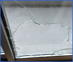 窓ガラスに複数のヒビが入った画像